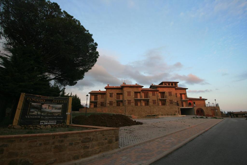 un gran edificio de ladrillo con un cartel delante en Case vacanze Villini panoramici sul Lago Trasimeno, en Castel Rigone