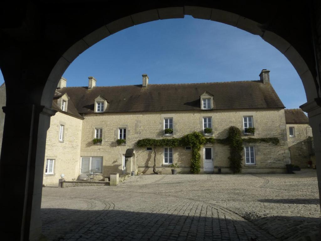 an archway in front of a large stone building at Gite LA CHARRETTERIE in Martragny
