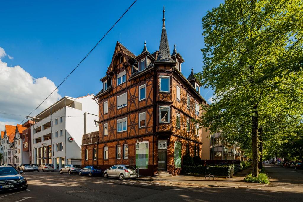 埃斯林根的住宿－SecondHome Stuttgart - 2 connected very nice and large apartments near historic city centre at Blumenstr 58 in Esslingen am Neckar - B W1-2，城市街道上一座带塔楼的古老建筑