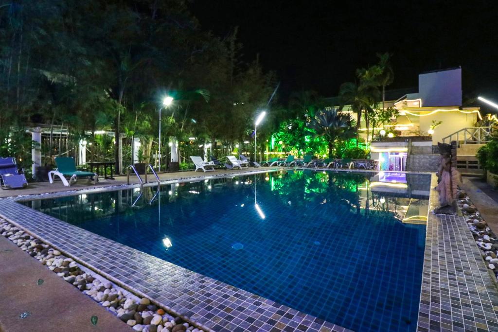 una piscina por la noche con luces encendidas en Natural Beach Hotel Pattaya, en Pattaya central