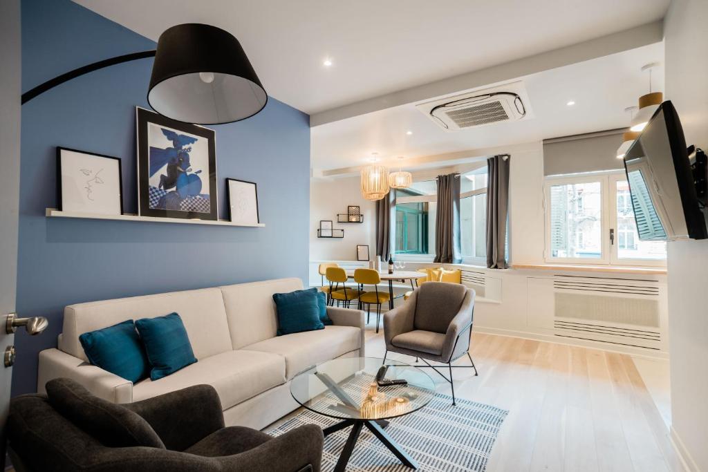 een woonkamer met een witte bank en blauwe muren bij SUITE APOLLINAIRE : au cœur de la Rive Gauche, neuf, design, 2/4 personnes in Parijs