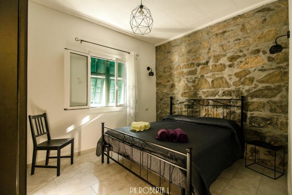 ein Schlafzimmer mit einem Bett und einer Steinmauer in der Unterkunft Accogliente Bussana 1 in Sanremo