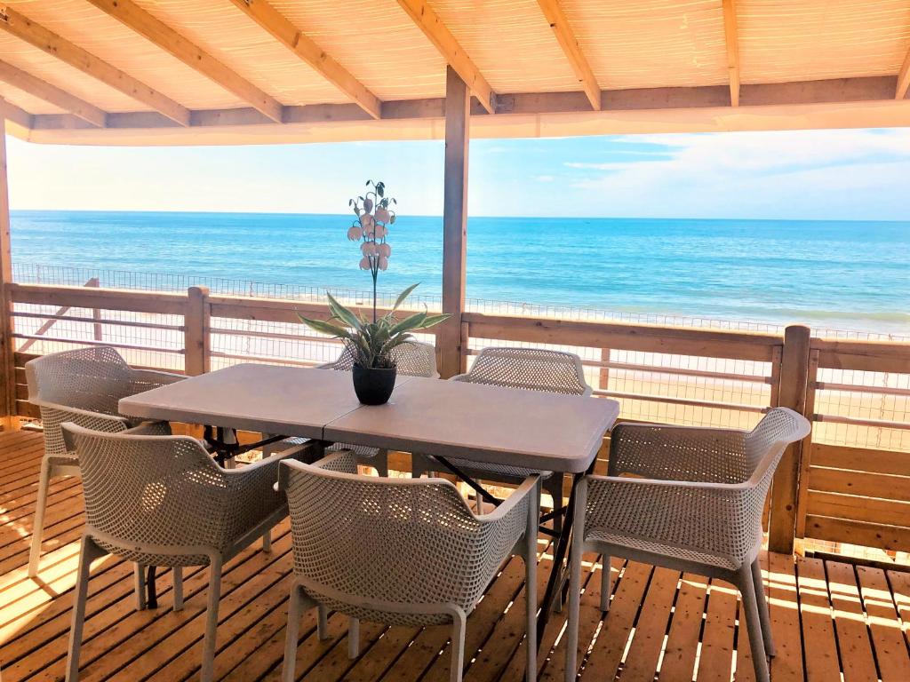LOCA BEACH في تغازوت: طاولة وكراسي على سطح مع المحيط