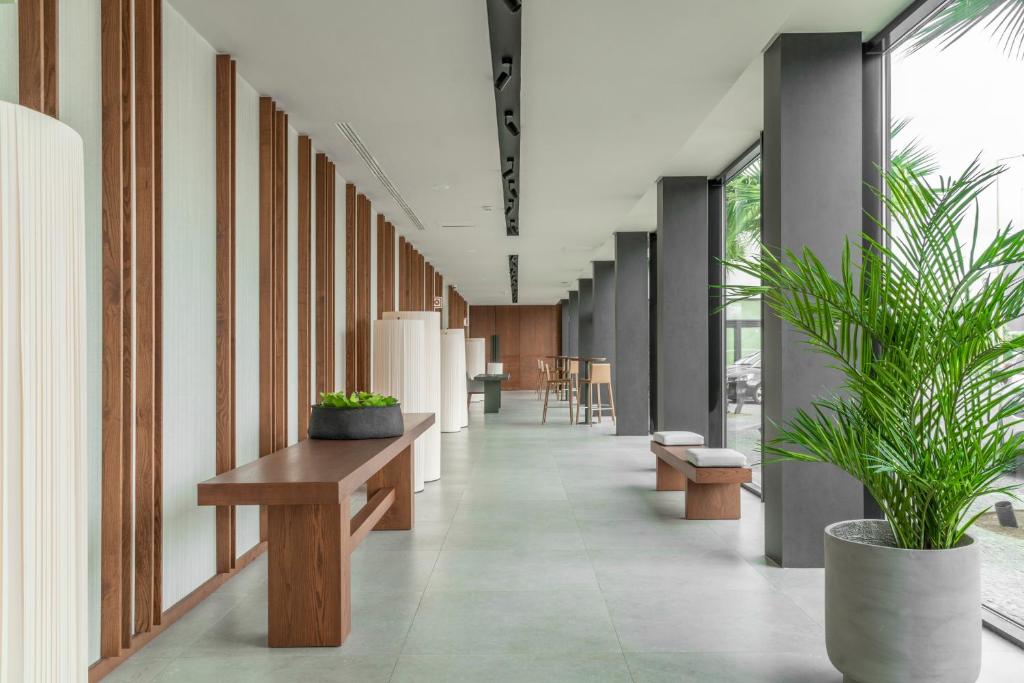 a hallway with benches and potted plants in a building at Hotel Verde Mar & SPA in Ribeira Grande