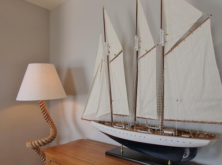 a model boat sitting on a table next to a lamp at Goose's Getaway in Wells next the Sea