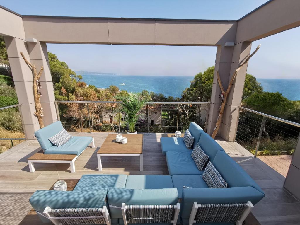 een patio met blauwe meubels en uitzicht op de oceaan bij Casa de la Luz in Begur