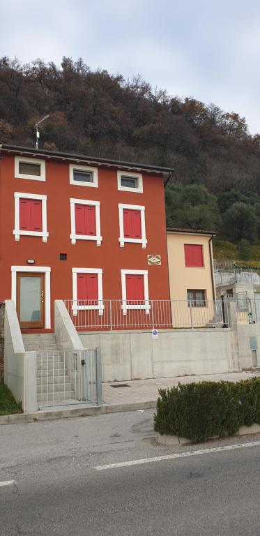 a red building with red windows on a street at Viale Asiago 288 in Bassano del Grappa