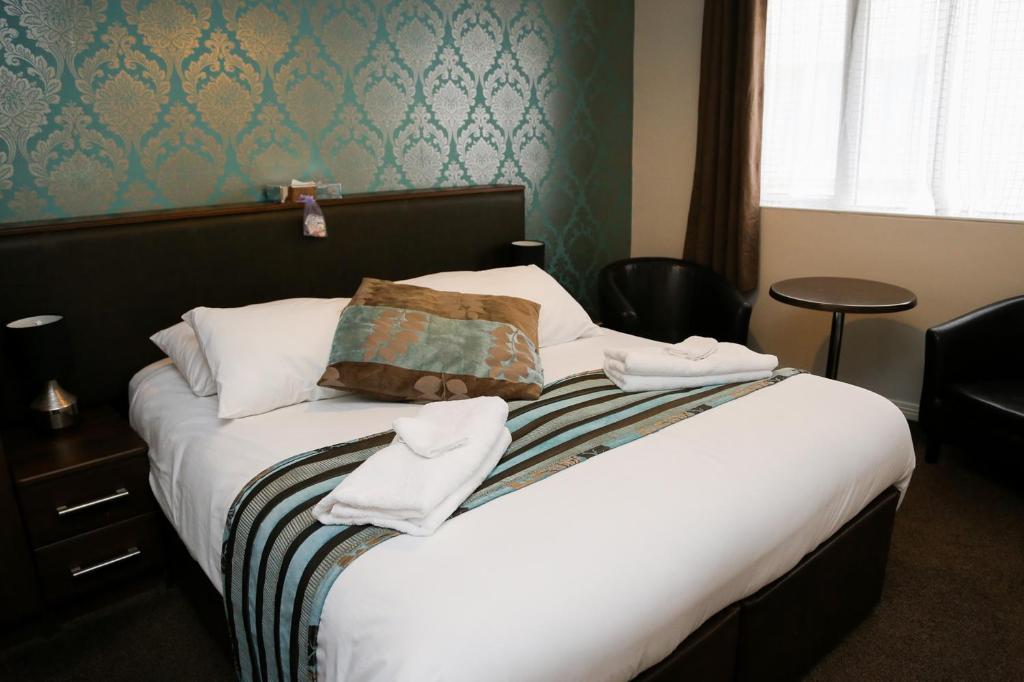 a hotel room with a bed with towels on it at Avarest House BB Adults Only in Portrush