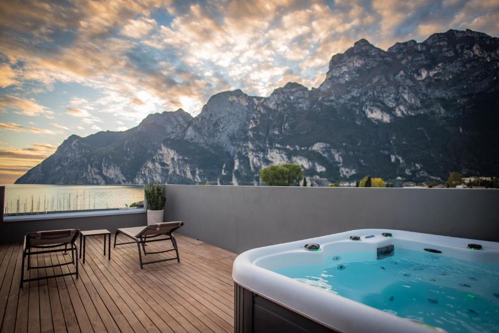 a hot tub on a deck with a view of a mountain at Hotel Villa Enrica in Riva del Garda