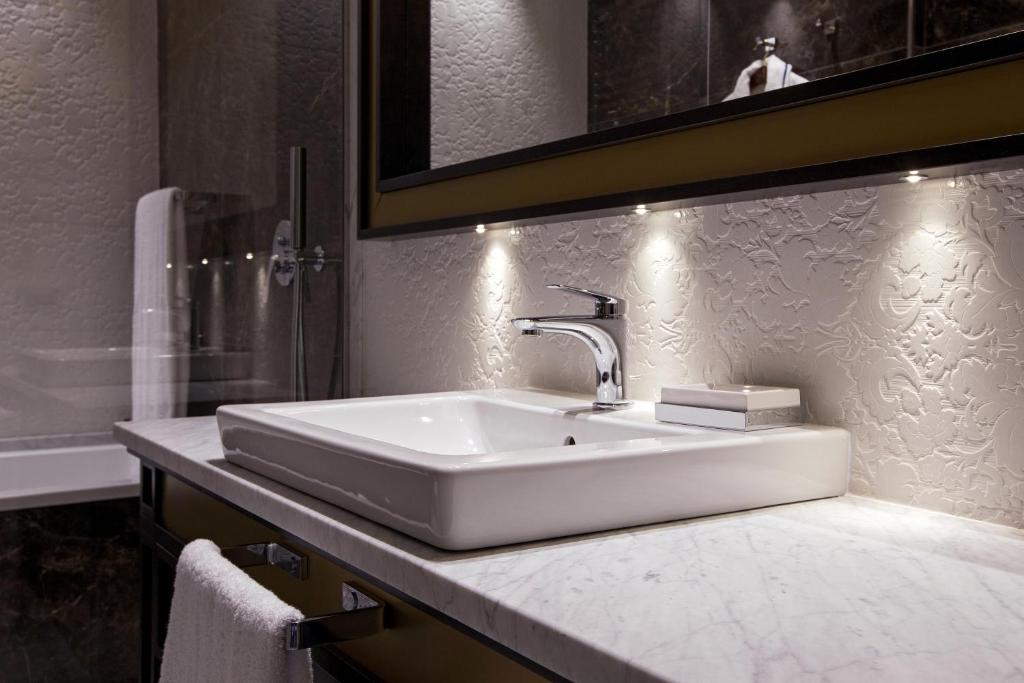 a bathroom with a white sink and a mirror at Palazzo Doglio in Cagliari