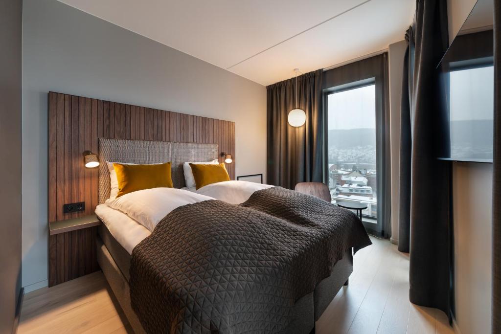 a bedroom with a large bed and a large window at Quality Hotel River Station in Drammen