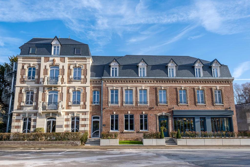 un grand bâtiment en briques avec un toit noir dans l&#39;établissement Mayrena Hotel Restaurant - Destination Le Tréport Mers, à Eu