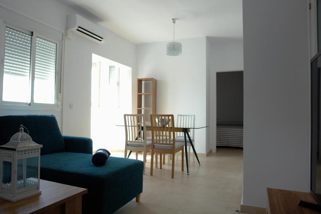 sala de estar con sofá, mesa y sillas en Apartamentos Costa de la Luz playa, en Rota