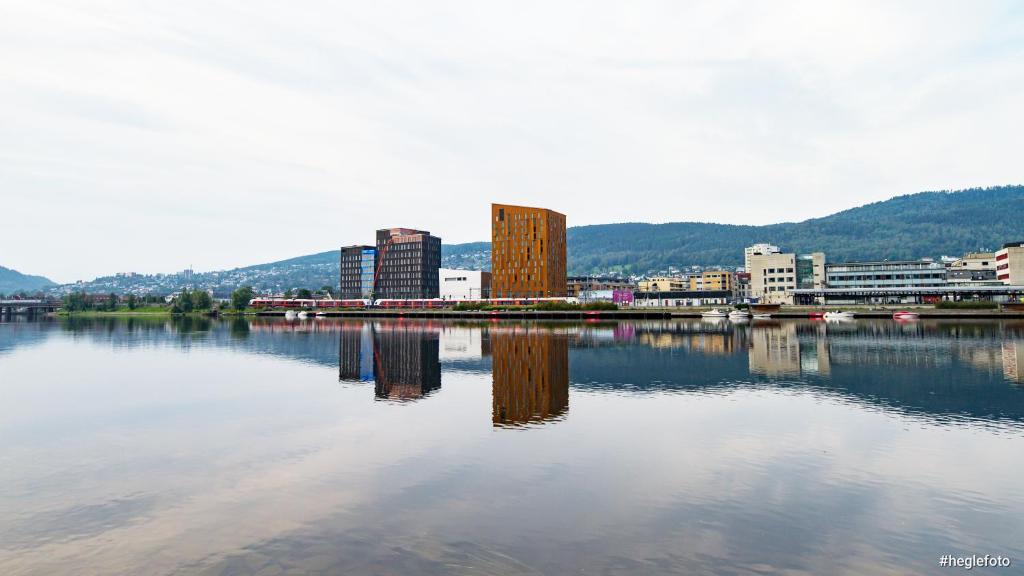 ein großer Wasserkörper mit einer Stadt und Gebäuden in der Unterkunft Quality Hotel River Station in Drammen