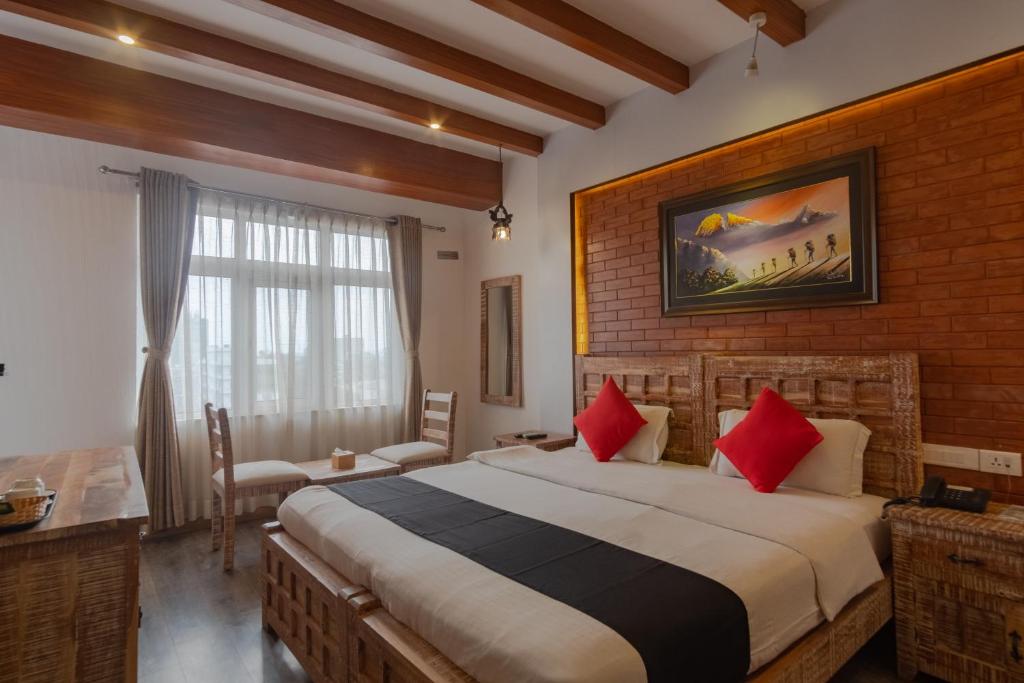 ein Schlafzimmer mit einem großen Bett mit roten Kissen in der Unterkunft Swornim Boutique Hotel Kathmandu by Tibet Peace Inn in Kathmandu