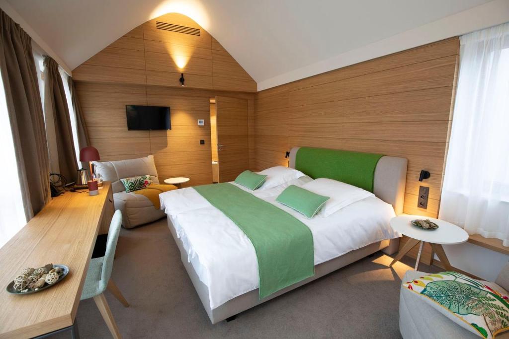 a large bedroom with a large bed and a couch at B-Lodge Boutique Hôtel in Louvain-la-Neuve