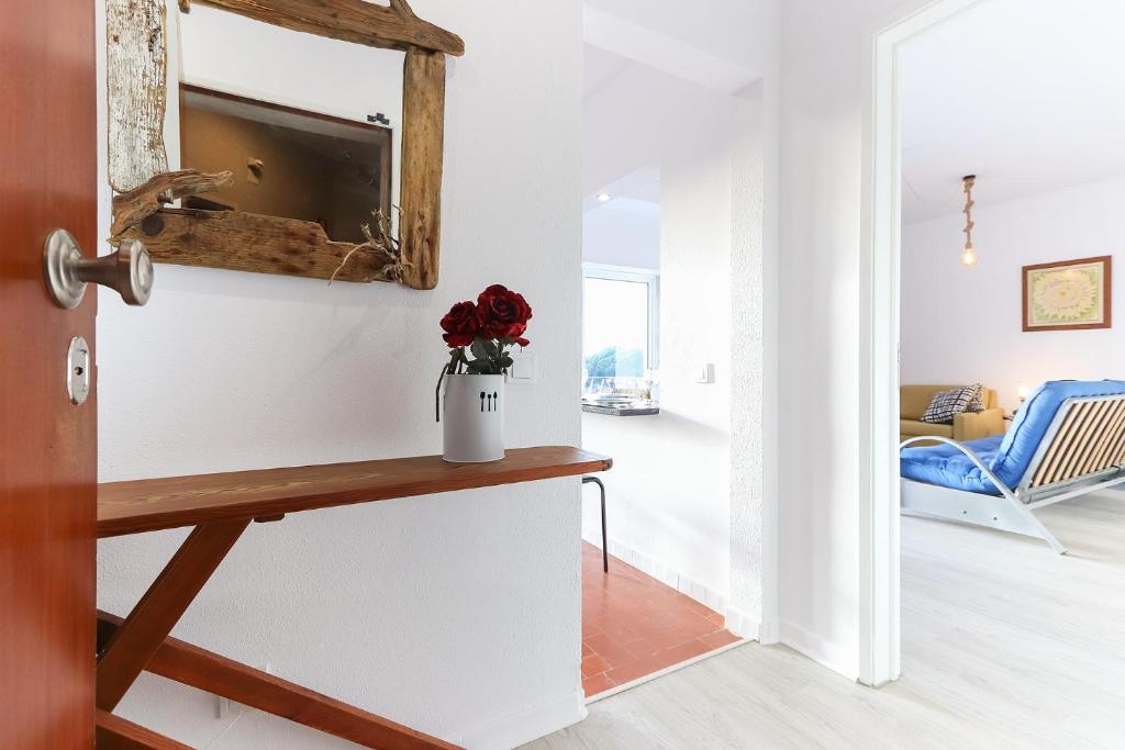 a living room with a television and a vase of flowers at Espectacular apartamento na praia a 20 min de Lisboa in Costa da Caparica