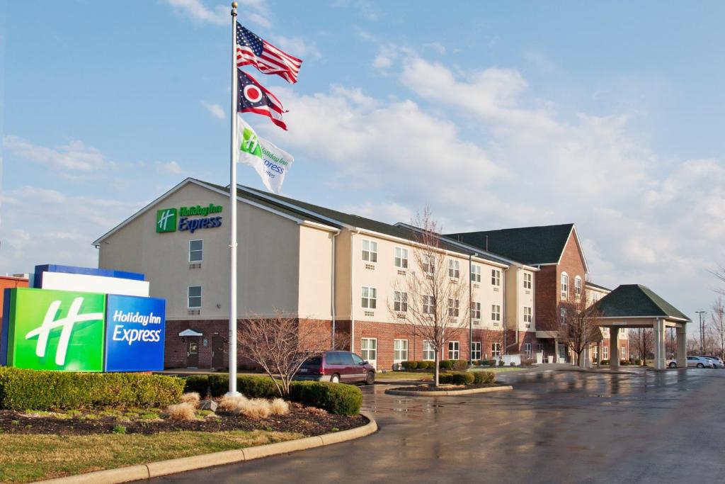 un hotel con banderas en un estacionamiento en Holiday Inn Express & Suites Columbus East - Reynoldsburg, an IHG Hotel en Reynoldsburg