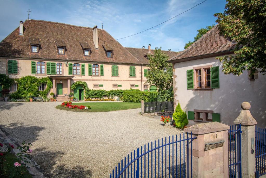 a large house with a blue fence in front of it at Gite **** Le Meyerhof in Rorschwihr