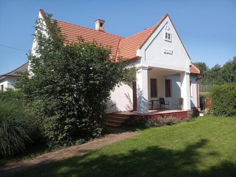 HerendにあるPark Vendégházの赤屋根の小さな白い家