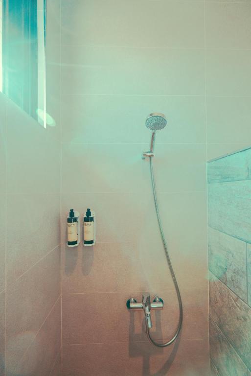 a shower with a shower head in a bathroom at Shark B&B in Hengchun