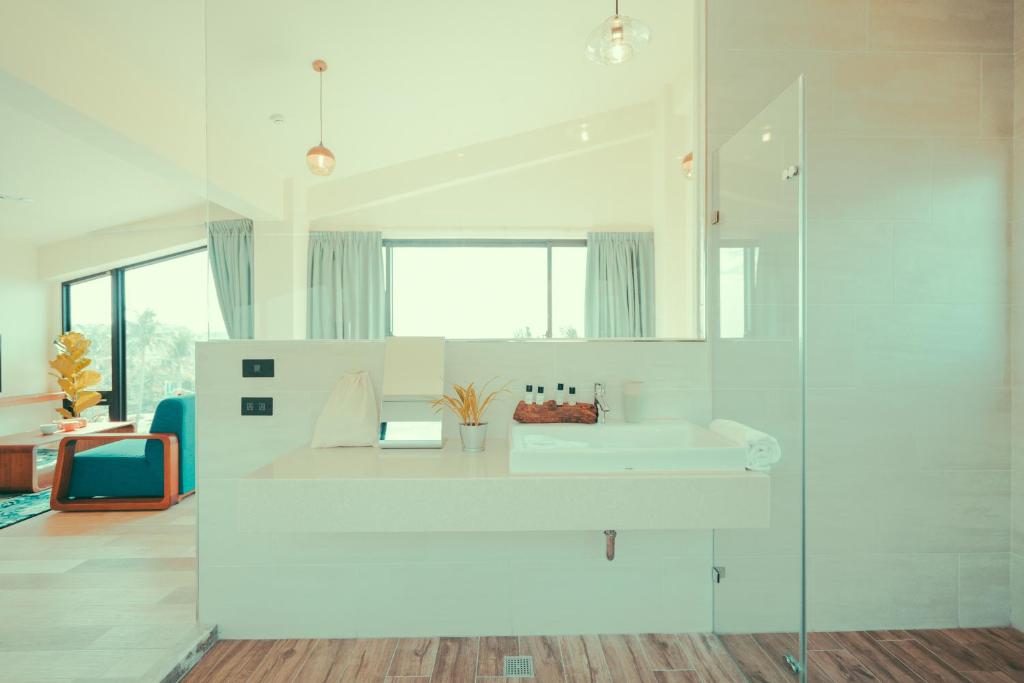 a white bathroom with a sink and a mirror at Shark B&B in Hengchun
