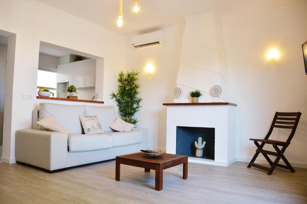 uma sala de estar com um sofá branco e uma lareira em Sea House Can Picafort em Can Picafort