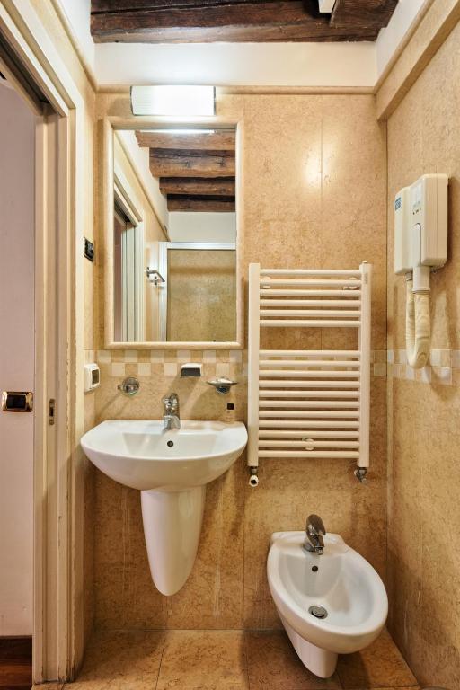 a bathroom with a sink and a mirror at Hotel Vecellio Venice on the Lagoon in Venice
