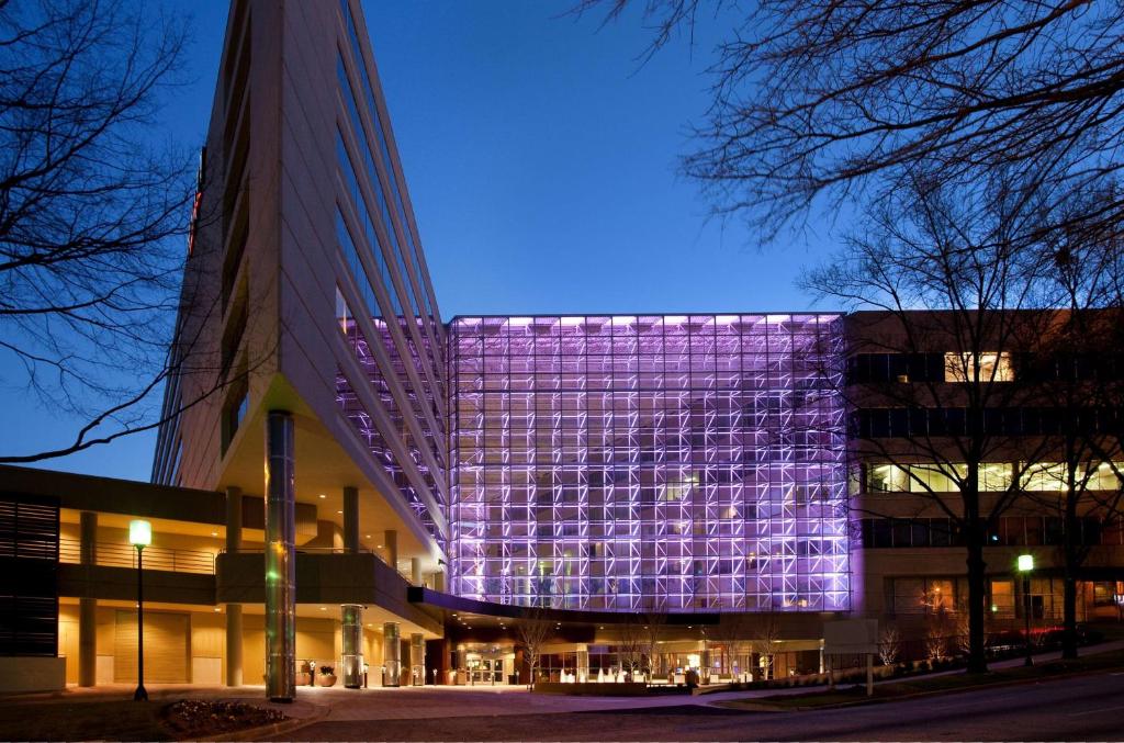 Un bâtiment avec des lumières violettes sur son côté dans l'établissement Hyatt Regency - Greenville, à Greenville