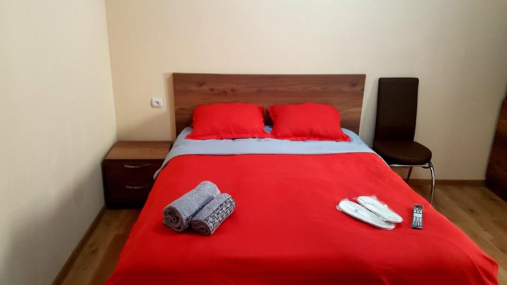 a red bed with two red pillows and towels on it at Guest house Jangulashvili in Sighnaghi