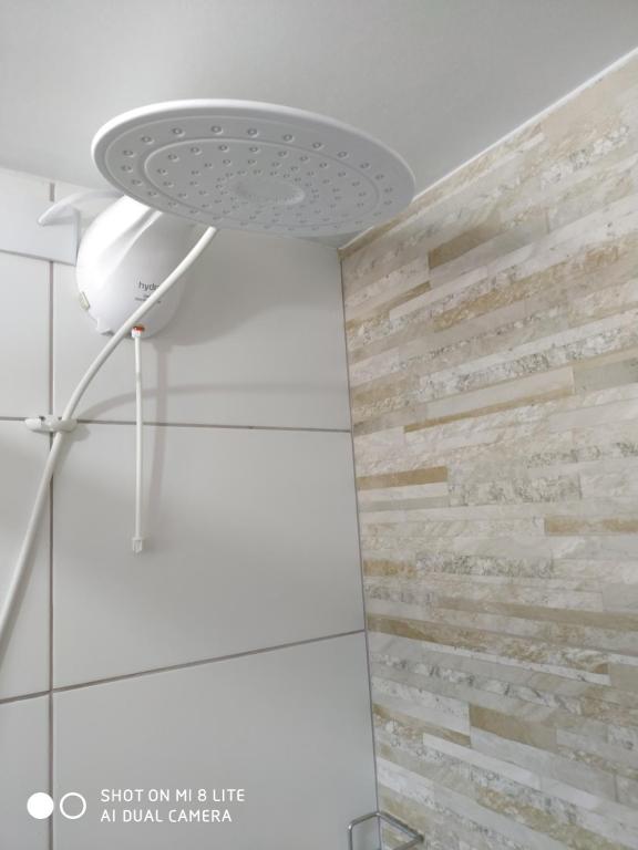 uma ventoinha de tecto na casa de banho com uma parede de pedra em Pousada Agradável Pomerode em Pomerode