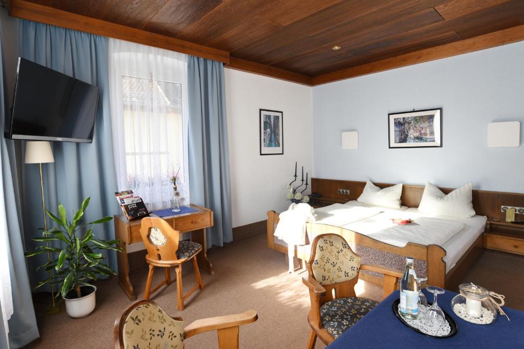 a hotel room with a bed and a table and chairs at Gasthof & Hotel Goldener Hirsch in Bad Berneck im Fichtelgebirge