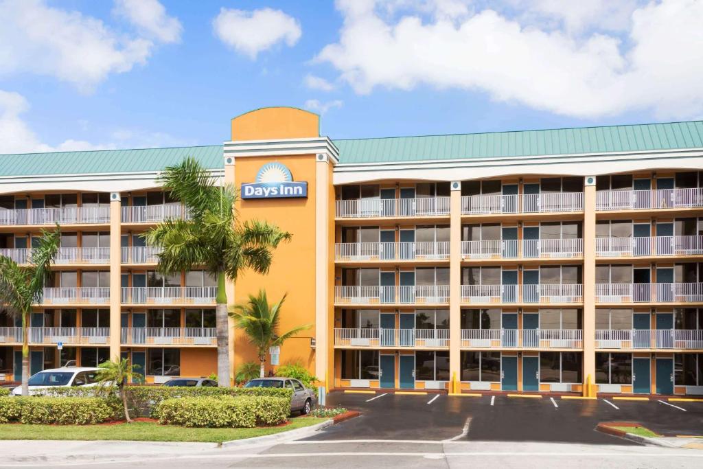 uma vista exterior de um hotel com estacionamento em Days Inn by Wyndham Fort Lauderdale-Oakland Park Airport N em Fort Lauderdale