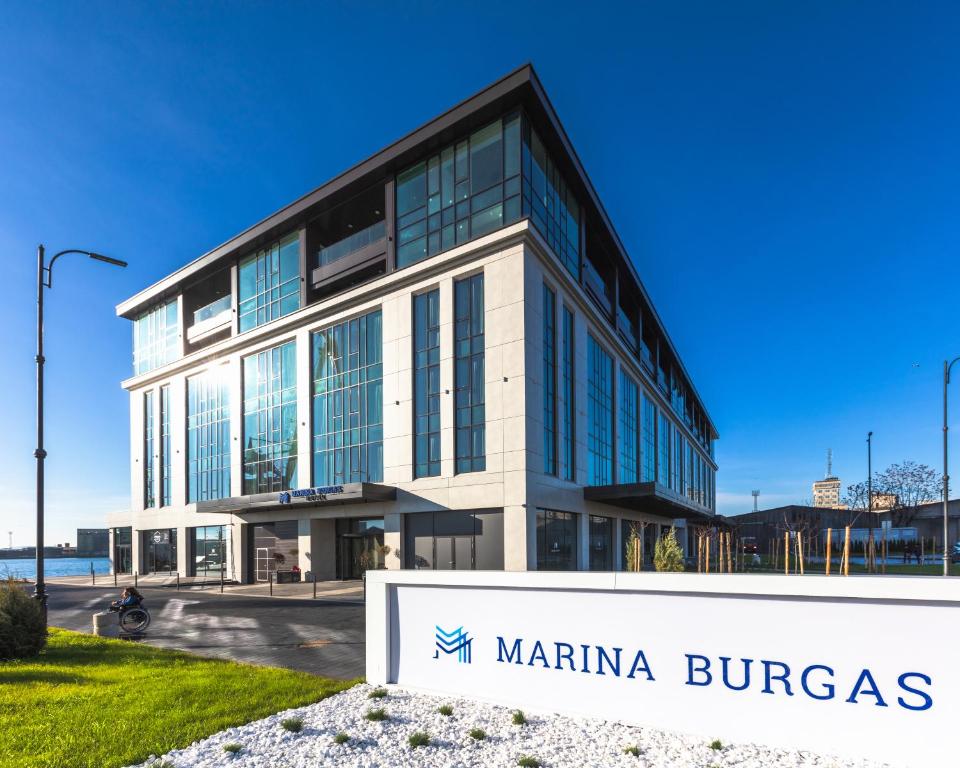 a large building with a sign on the side of it at Marina Burgas Hotel in Burgas