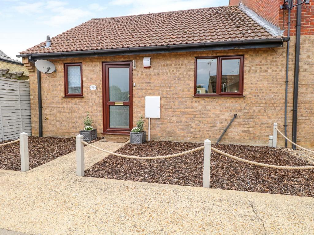a house with a fence in front of it at Village Retreat in Ely