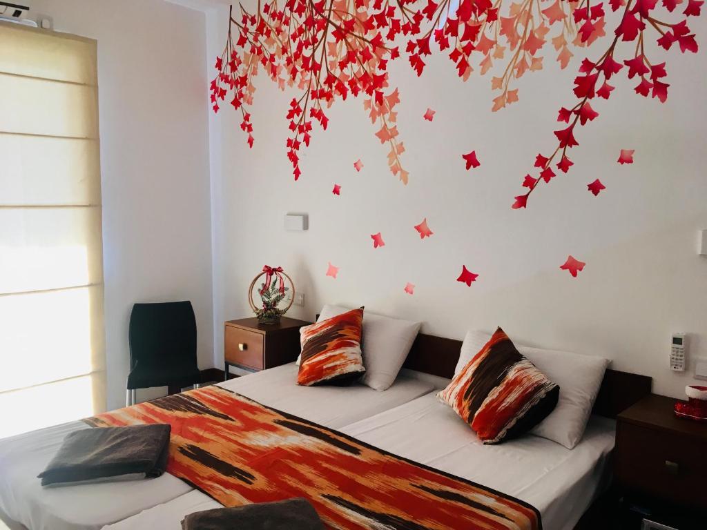 1 dormitorio con 1 cama con estrellas rojas en la pared en Visakha 6, en Colombo