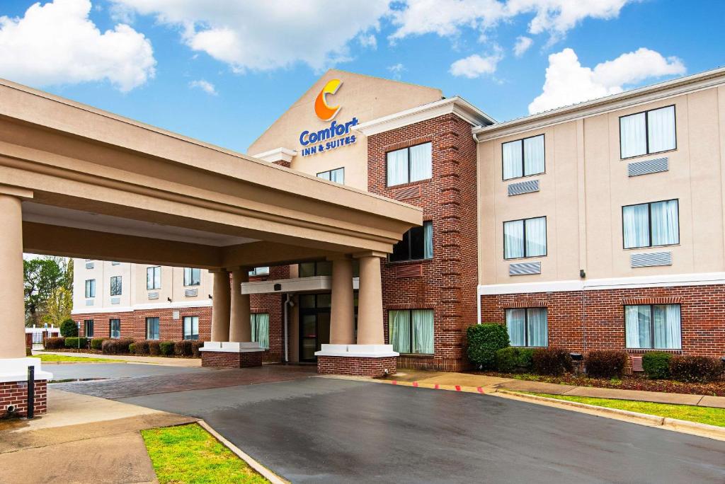 Comfort Inn & Suites Pine Bluff في باين بلاف: مبنى الفندق وامامه موقف سيارات