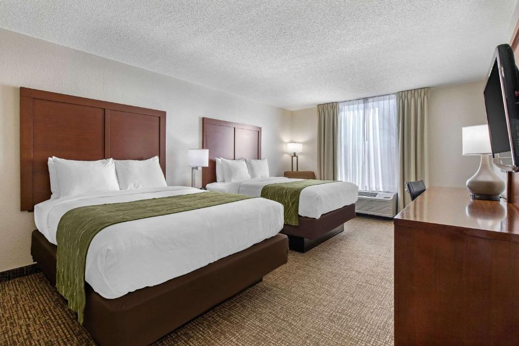 a hotel room with two beds and a flat screen tv at Comfort Inn in Shelby