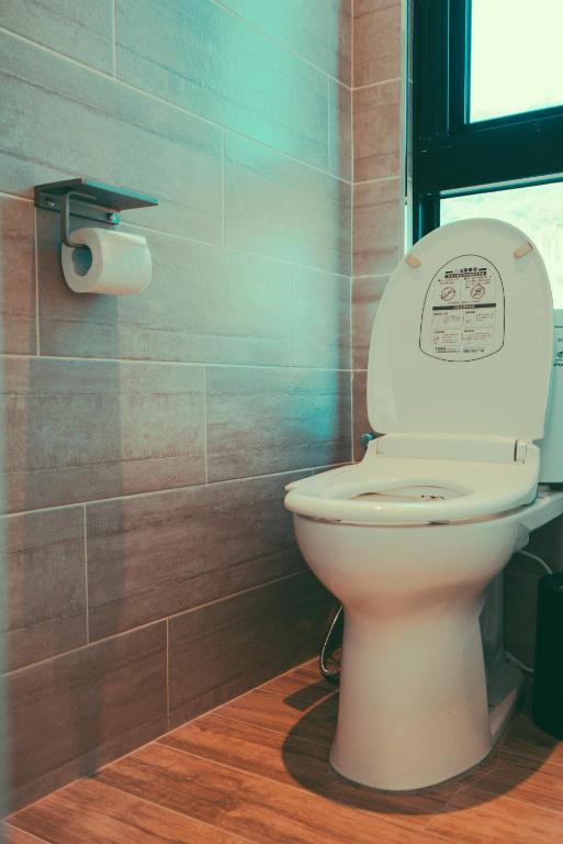 a bathroom with a toilet and a roll of toilet paper at Shark B&B in Hengchun