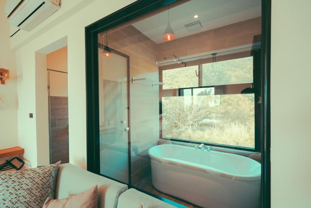 a bathroom with a bath tub and a window at Shark B&B in Hengchun