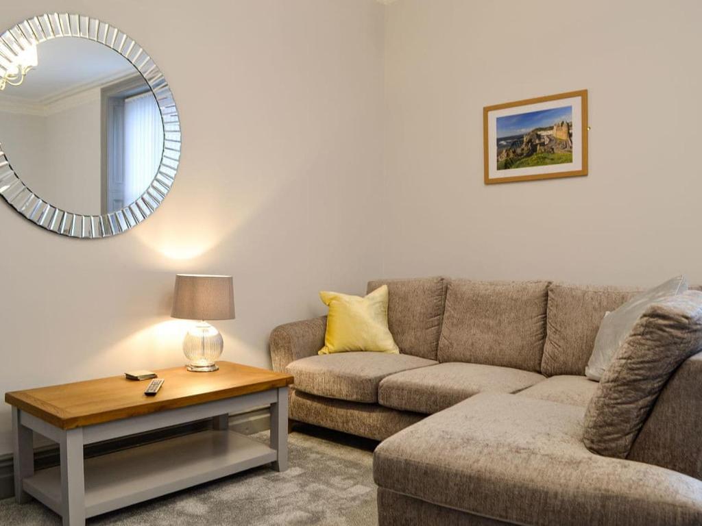 a living room with a couch and a mirror at Grosvenor House APT 3 in Aberystwyth