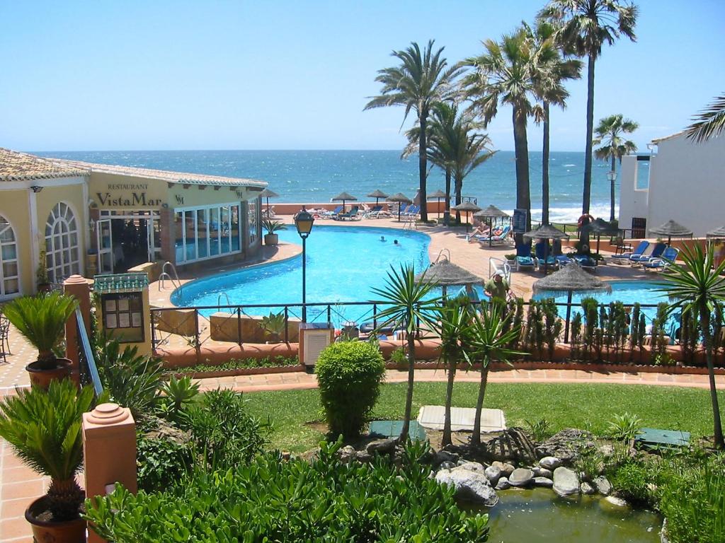 a large swimming pool with the ocean in the background at Apartment Dona Lola by Interhome in Sitio de Calahonda