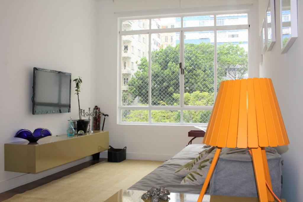 a room with a bed and a large window at Design e sofisticação em Higienópolis in Sao Paulo
