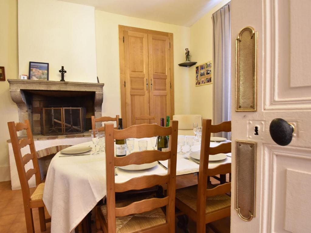 a dining room with a table with chairs and a fireplace at Gorgeous Holiday Home in Martigny le Comte with private Pool in Martigny-le-Comte