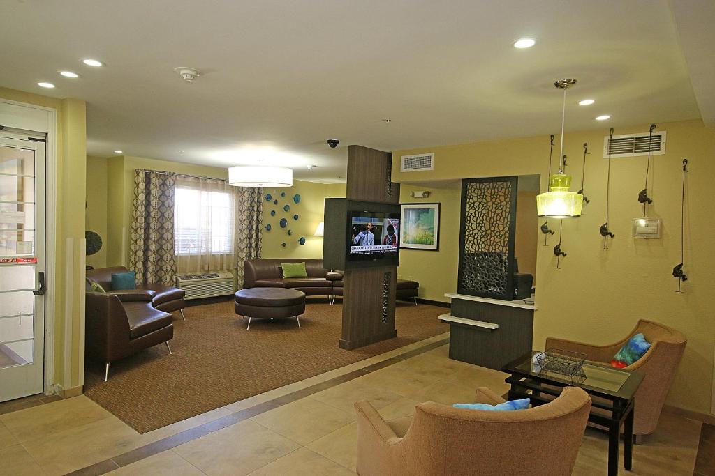 Il comprend un salon doté de meubles et d'une télévision. dans l'établissement Candlewood Suites Newport News-Yorktown, an IHG Hotel, à Newport News