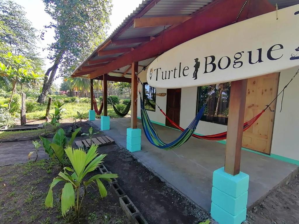 een bord voor een klein huis met een hangmat bij Casa turtle Bogue in Tortuguero