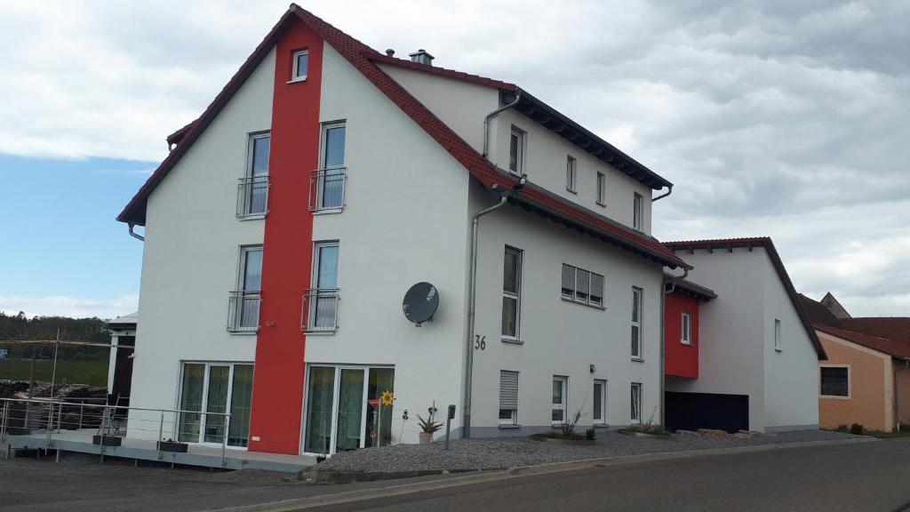 a white building with red trim on a street at Privatzimmer Popp-Hessenauer in Ansbach