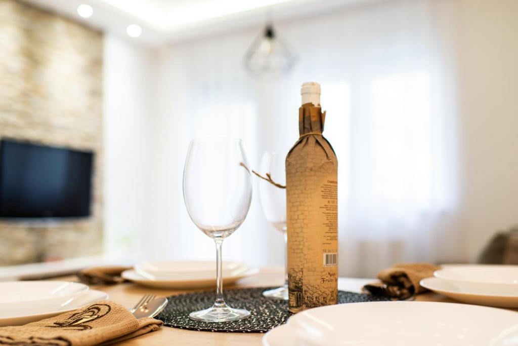 a bottle of wine and a glass on a table at Reset Apartment in Novi Sad