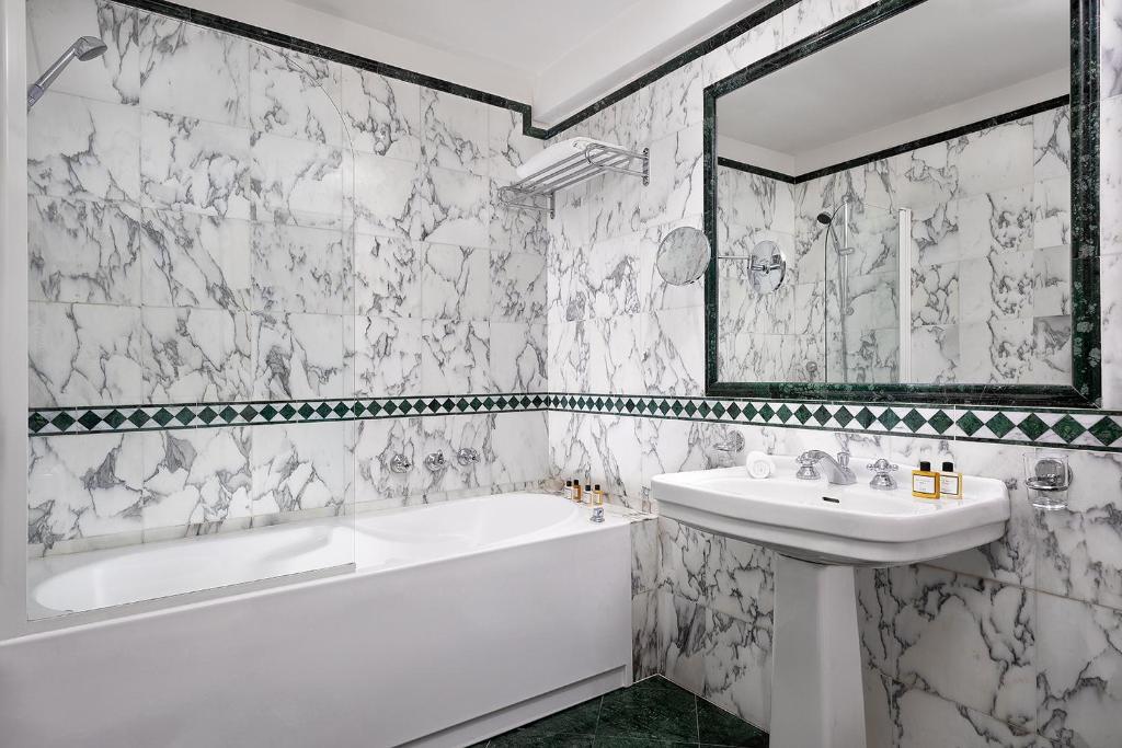 a white bathroom with a tub and a sink at Sina Palazzo Sant'Angelo in Venice