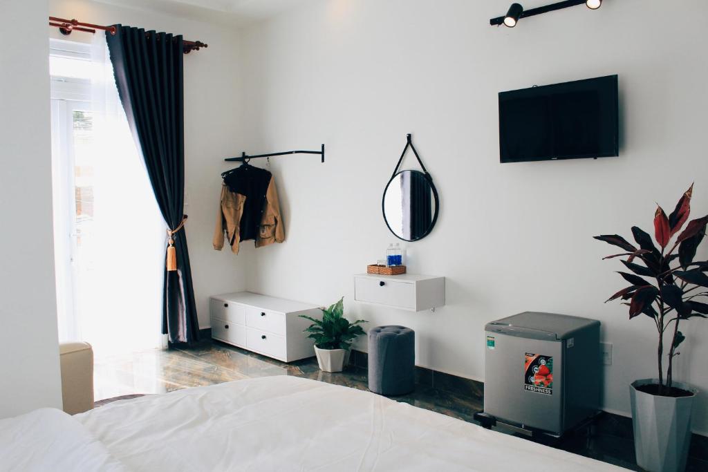 a bedroom with a bed and a tv on a wall at Sally Villa Homestay in Da Lat
